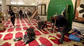 Palestinians clean the al-Aqsa mosque following clashes with Israeli security forces in Jerusalem's Old City