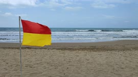 Rough seas and lifeguard flag on a beach in Turkey with nobody in the video