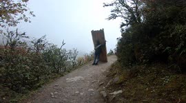 A man carries super heavy load at an altitude of 3900m around everest region