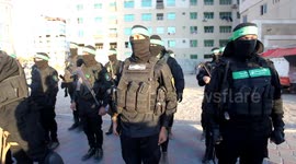 Members of the Izz al-Din al-Qassam Brigades, the military wing of the Islamic movement Hamas distribute dates and water to people on the street before sunset during the month of Ramadan