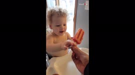 Curious toddler tries popsicle for first time but attempts to eat handle