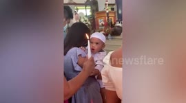 Baby boy determined to blow out candle during his baptism