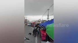 Strong gusts nearly blow away vendor's market stall in northeastern Thailand