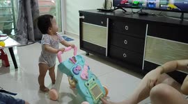 Baby falling down on floor after too excited waving her hand with her parents
