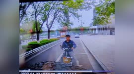 Cyclist distracted by phone almost hits car while riding along road in China