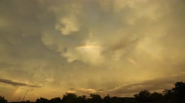 Sunset Behind Line of Storms With Rainbow Appearing Intermittently