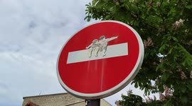 Street arts on road sign are numerous in Paris and its region. Children sit on the bar of a prohibited direction sign. 7 may 2022. Rue Jean le galleu, Ivry-sur-Seine, Paris suburb, France