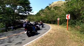 Motorbike rider skids across road after losing his balance while doing stunts