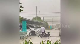 Hero passer-by helps motorcycle rider who fell over in the rain