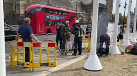 Police officers climb down a manhole in Parliament Square, London