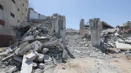 Palestinian workers remove the rubbles of a Building which was hit by Israeli strikes