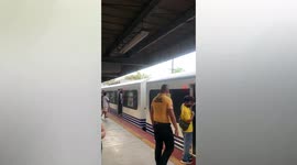 Train station worker squashes passengers inside overloaded carriage in the Philippines