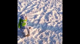 A monkey in a children's costume walks on the street in the snow