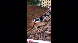 Multiple vehicles crushed after wall collapses due to heavy rain in southern China