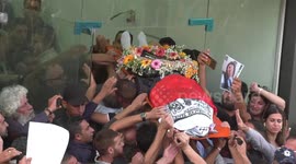 Palestinians carry flag-draped body of journalist Shireen Abu Akleh as it is brought to Al-Jazeera offices