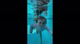 Enthusiastic infant seems to be a natural-born swimmer