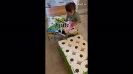 'Clumsy toddler bangs her head on the floor while playing with paper towel packages '