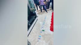 Family play soda can rolling game with cash prizes during Eid Al-Fitr festivities