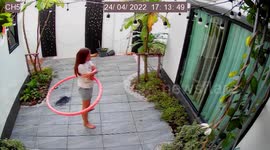 Deadly cobra slithers through woman's garden while she exercises with hula hoop
