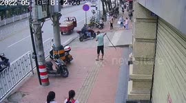 Brave pedestrian casually catches snake without ending his phone call