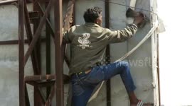 Brave expert climbs 60-foot billboard in western India to rescue stranded pigeon