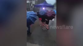 Locals carry on with Covid-19 screening despite rainstorm battering testing site in China