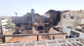 Palestinians inspect a house that was burnt during an Israeli military raid