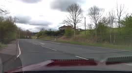Dashcam footage of car overtaking at speed and narrowly missing an oncoming vehicle.