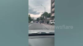 Motorcyclist carries huge roll of metal on his shoulder