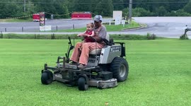 Boy rides in lawn mower