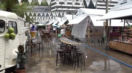 Stall-holders clear water from flooded market after heavy rain in Bangkok, Thailand