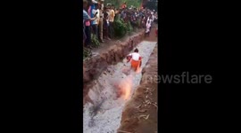 Hindu priest trips and falls onto hot coal during firewalking ritual in India