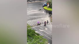 Kind-hearted Chinese women struggle to move manhole cover that was washed away by water back