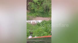 Overflowing spillway halts motorists as monsoon rains hit the Philippines