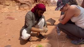 Bedouin from Jordan's Wadi Rum shows tourist how to make soap from plants
