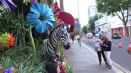Locals enjoy taking pictures outside The Ivy Asia Chelsea with fun animal scuptures of Ivy Band and wildflowers
