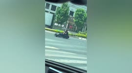 Father drives toy car across road with his child onboard in China