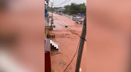 Muddy torrents surge through flooded street after heavy rain in Myanmar