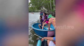 Hilarious moment tourist teeters on edge of spinning basket boat in Thailand
