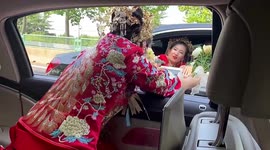 Brides exchange bouquets as they drive past each other on road in China