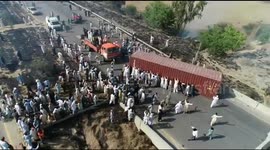 Anti-government protesters push shipping containers out of the way of their march on Islamabad, Pakistan