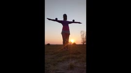'Woman puts on a mesmerizing contact juggling performance during sunset '