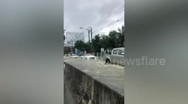 Bumper-level flood swamps road after heavy rain in northern Thailand