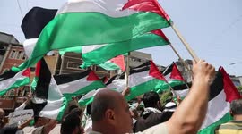 Palestinians wave their national flag during Gaza protest