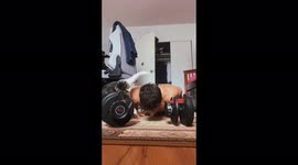 The cat prevents the guy from doing push-ups from the floor