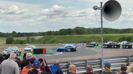 Race car spins in front of crowd which is a sitting duck and gets hit side on by an incoming race car