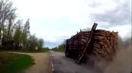 Quick-thinking driver swerves to avoid logs falling from a timber truck in Russia