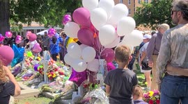 Boy comforts his baby brother at the Uvalde  Is memorial for the victims of the Uvalde shooting massacre