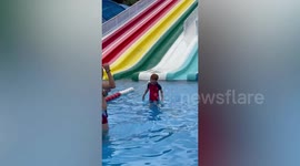 Boy pushes himself down waterslide after finding it not slippery enough