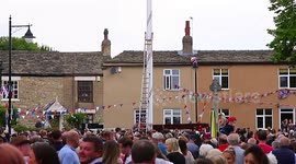 Local village man seen scaling the UK's tallest Maypole in West Yorkshire